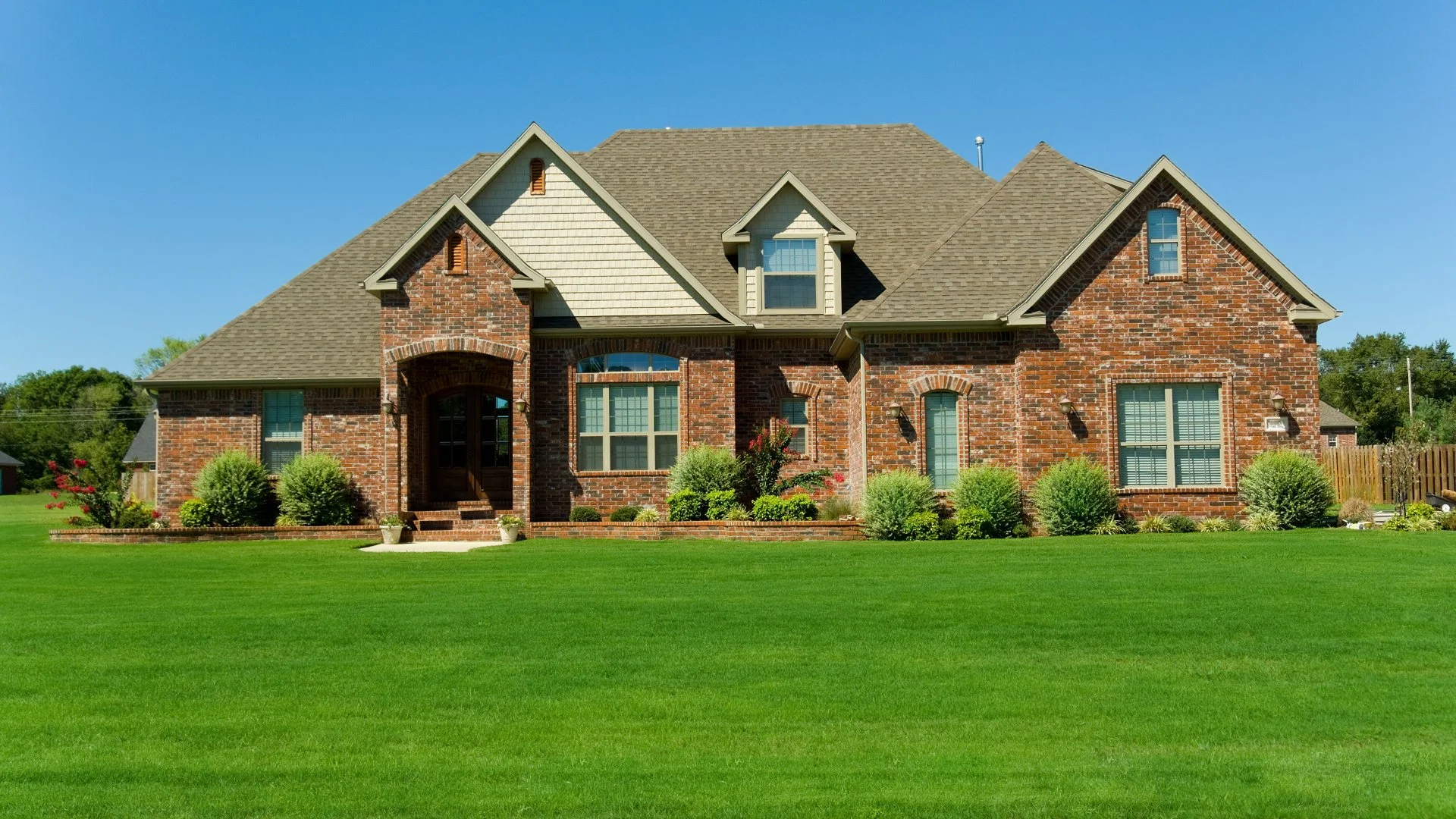 Lush lawn and shrubs in front of house in Windsor Park, TX